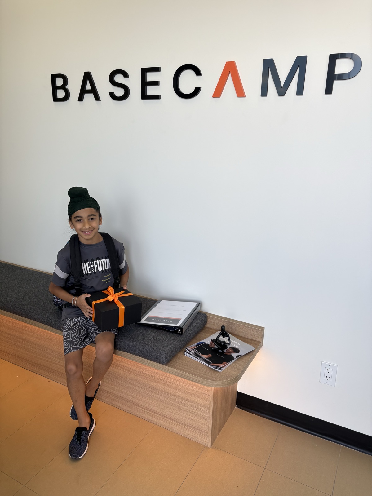 A student with a welcome gift box in the Basecamp Oakville lobby